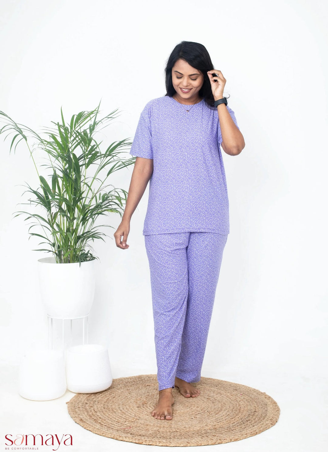 Woman wearing lilac heart pant set with relaxed fit and soft cotton fabric standing indoors near plants