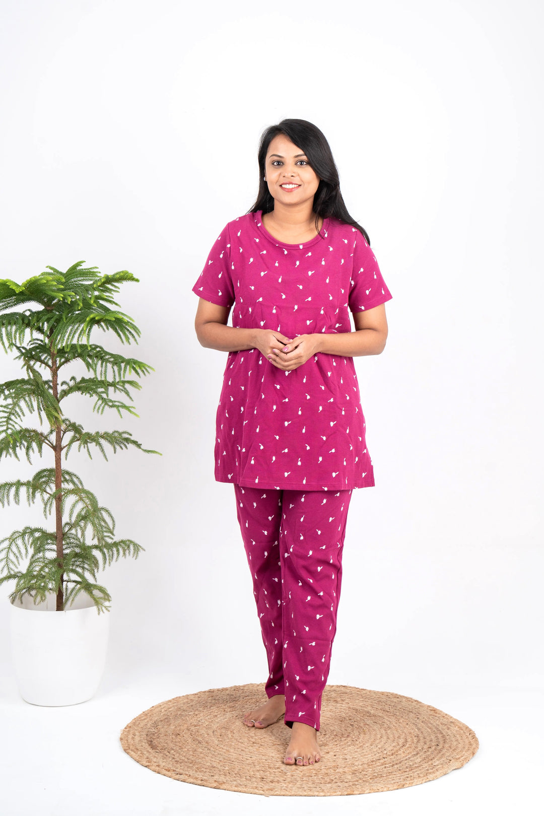 Woman wearing magenta waffle feeding pant set with floral print and short sleeves, designed for nursing and comfort