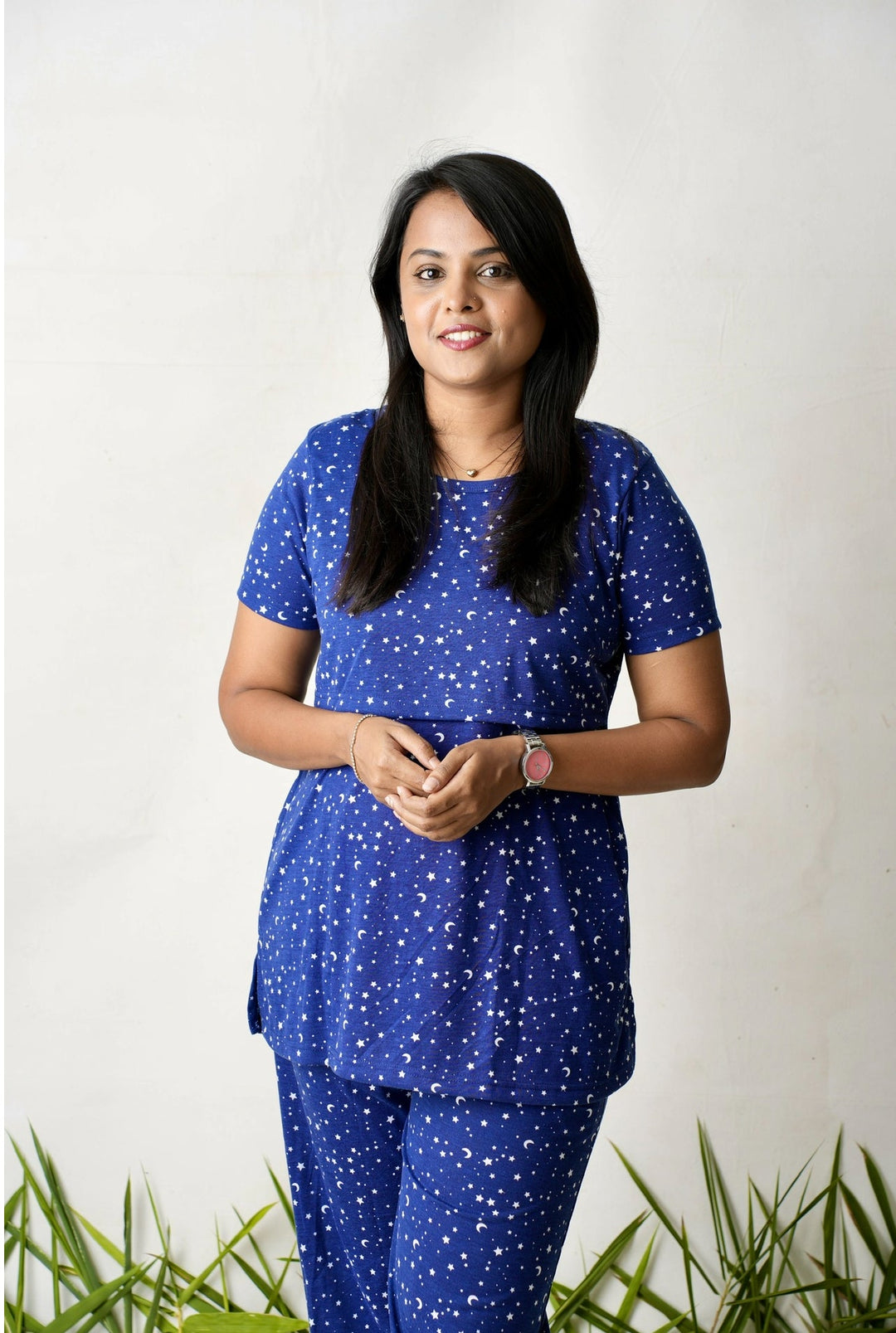 Woman wearing navy blue star printed nursing top and pants feeding pant set
