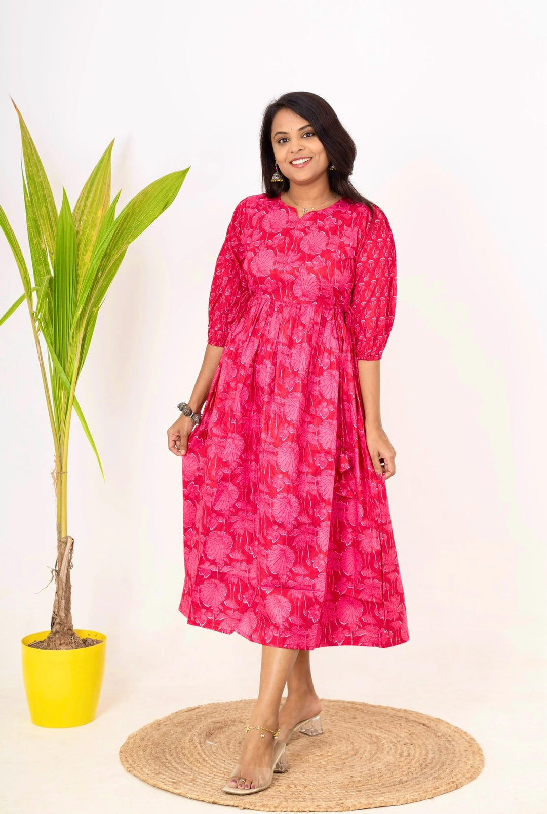 woman wearing pink floral cotton day to night dress with 3/4 sleeves and round neckline