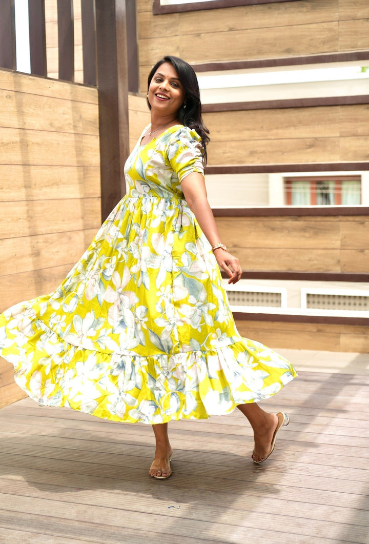 Woman wearing yellow floral Flora Casual Dress with lining and double side zipper, twirling outdoors on wooden deck