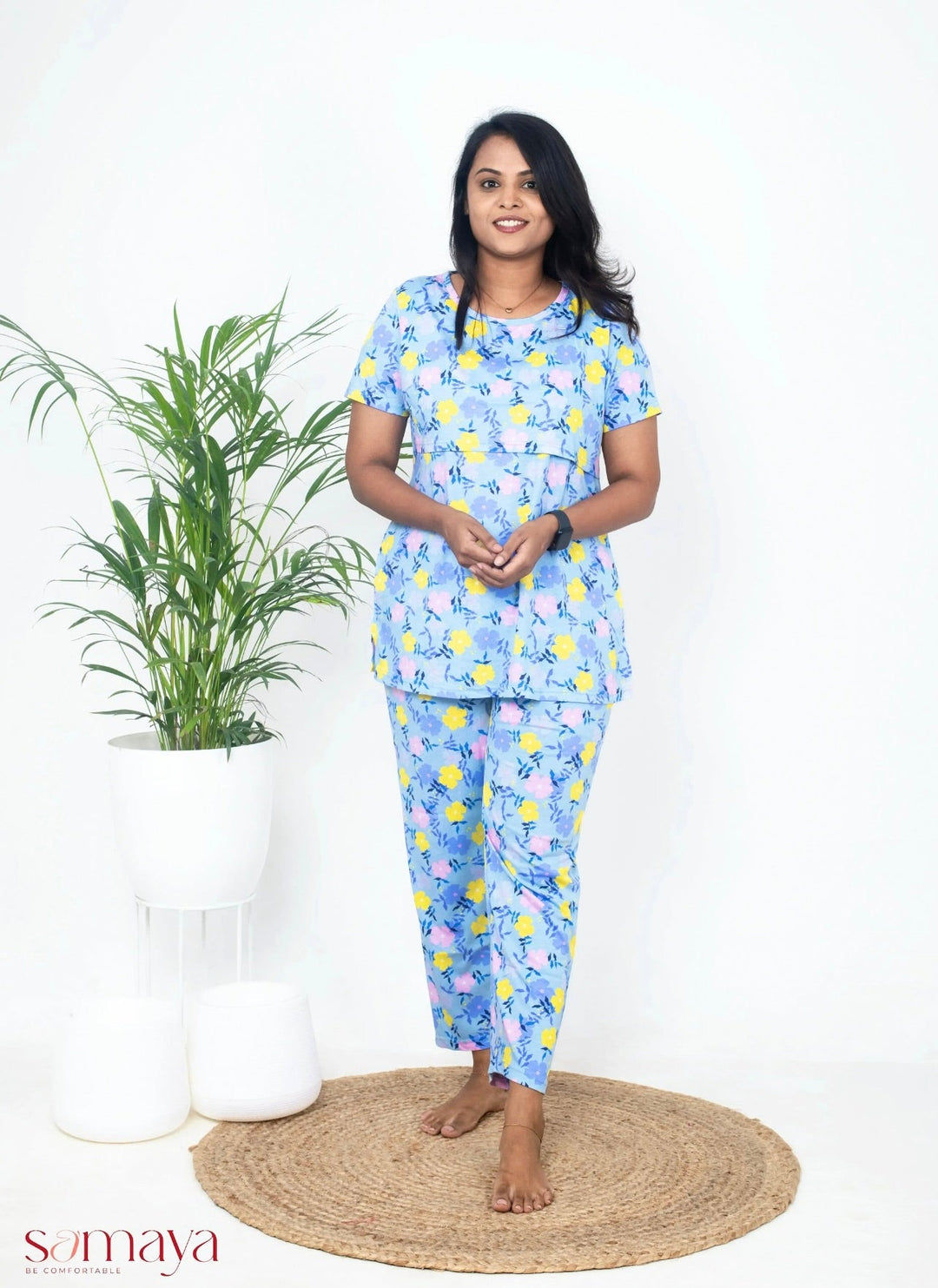 Woman wearing blue flower feeding pant set maternity loungewear with nursing flap and short sleeves