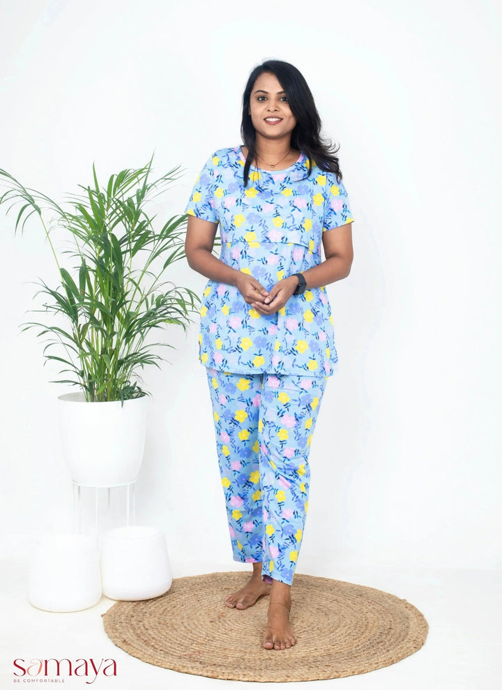 Woman wearing blue flower feeding pant set maternity loungewear with nursing flap and short sleeves