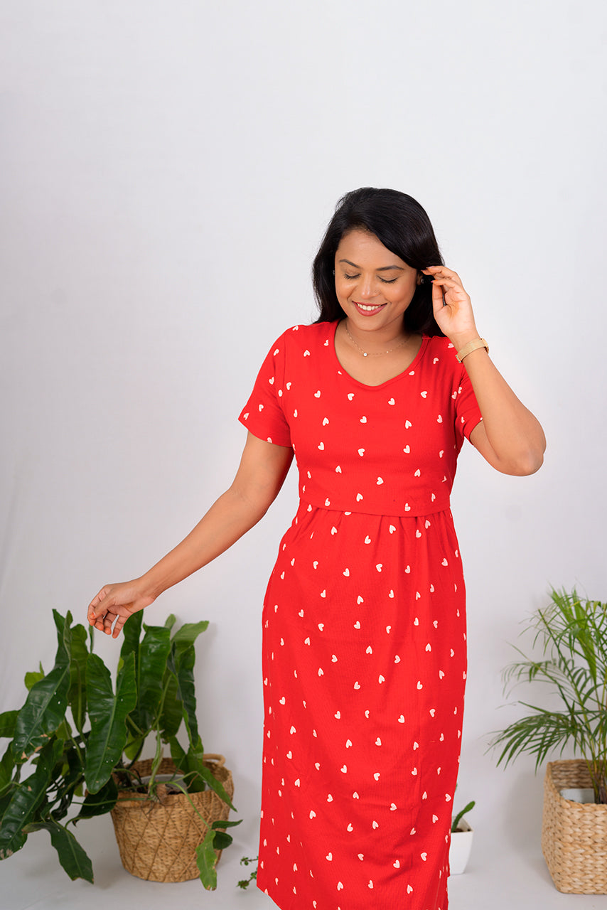 Woman wearing red Midi Ribbed Lolita Dress with heart print, short sleeves, and nursing flap.