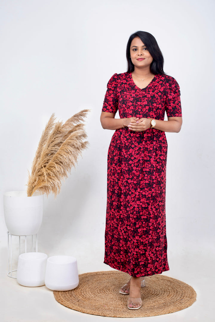 Woman wearing Luxury Maxi Roja floral print maternity nursing dress with V neck and puff elbow sleeves standing indoors