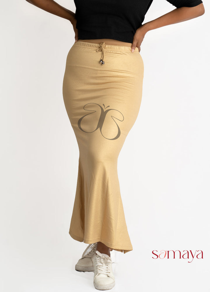 Gold buttersoft shimmer sareeshaper with drawstring waist and flared bottom, modeled by person wearing black top and white sneakers.