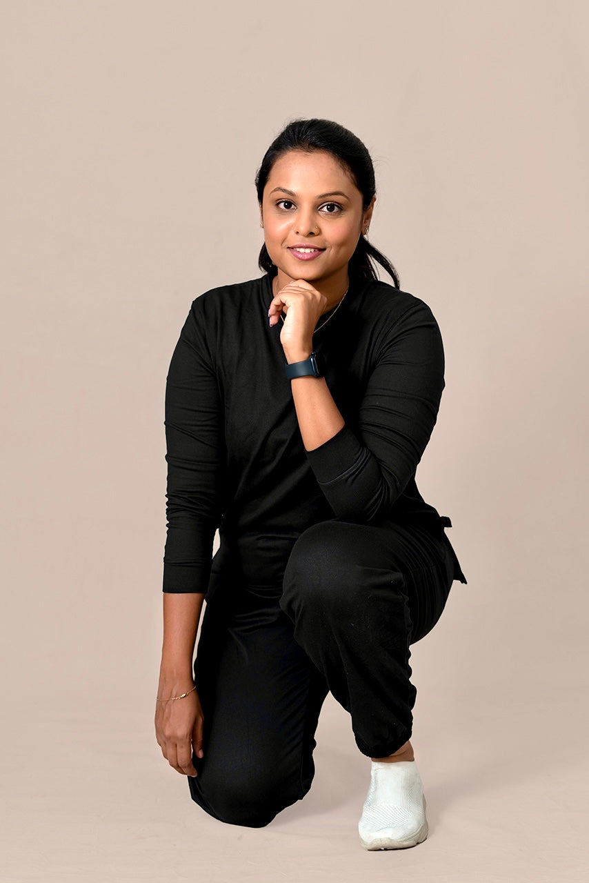 Woman wearing jet black Everyday Cozy Set winter premium fabric with relaxed fit and two pockets, posing against plain background